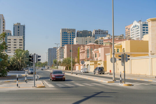 Central Abu Dhabi, United Arab Emirates, with modern cityscape, apartment buildings, villas, and cars.

