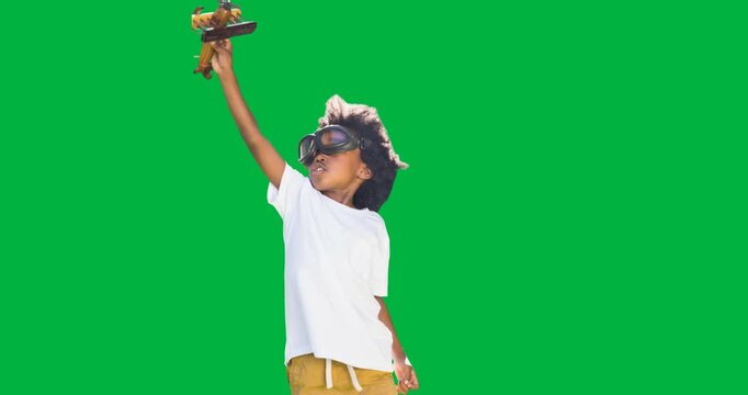 African american boy in pilot costume playing with airplane toy against transparent background