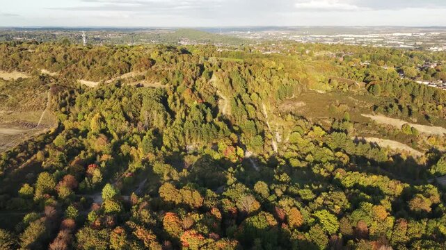 Drone glides over the ruins of Sheffield Ski Village, revealing autumn-colored forest trails and distant city buildings&mdash;capturing the contrast between nature, decay, and urban proximity