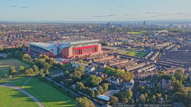 Stunning aerial drone footage of Liverpool FC&rsquo;s iconic Anfield stadium in Liverpool, England, filmed during sunset. The golden-hour light enhances the famous football ground, surrounding cityscape.