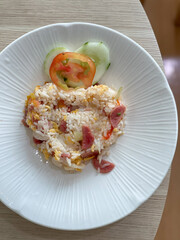 Thai style fried rice with pork, cucumber with chili in fish sauce in small cup on plate, Thai food.