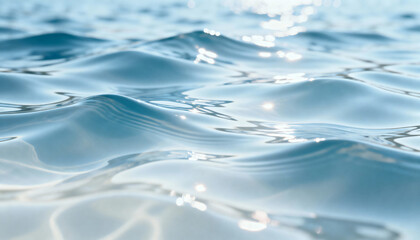 Light blue water surface with gentle waves and sparkling bokeh