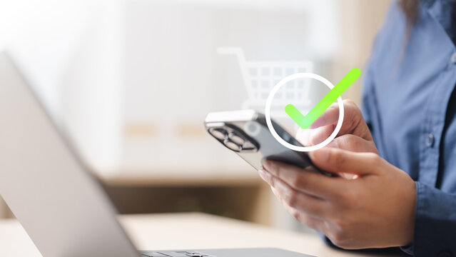 order, confirmed, success, Close-up of person holding smartphone with digital check mark icon, symbolizing confirmed order, successful e-commerce purchase, and secure online transaction status.