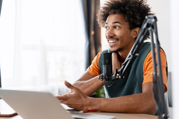 Young black man recording podcast speaking into microphone