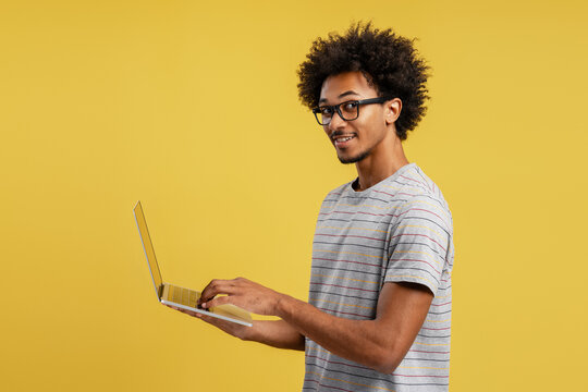 Young smiling man in glasses using laptop - Powered by Adobe
