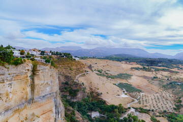 Ronda, spain, town built on a cliff edge with arid fields and distant mountains in ronda,malaga,spain