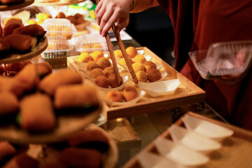 close up of a woman's hands serving bitterballen on a wooden tray