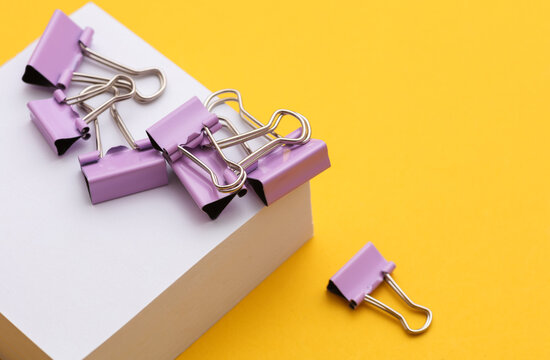Stack of white memo papers with binders on yellow background
