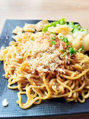 Authentic Indonesian Fried Noodle Dish (Mie Goreng) Plated on a Wooden Texture Table