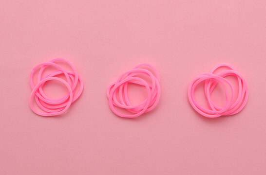 Pink stationary rubber bands on a pink background