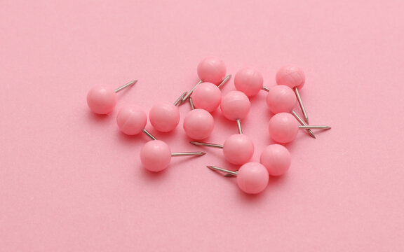 Set of stationery paper pins on pink background