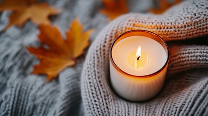 cozy home lifestyle niche Cozy Autumn Candle on Knitted Sweater with Fall Leaves warm ambiance daily routine comfortable aesthetic for ads