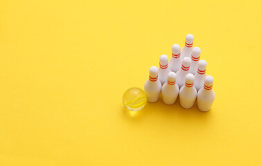 Miniature bowling, pins with ball on yellow background