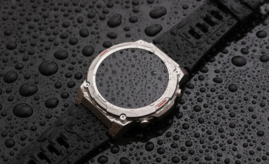 Modern smart watch bracelet with water drops on black background. Waterproof technologies