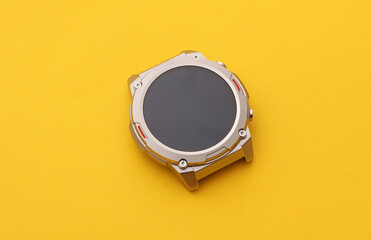 Obraz premium Bezel of modern smart watch without strap on yellow background