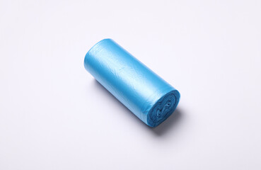 Roll of blue garbage bags on white background