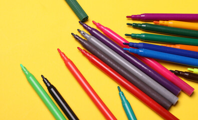 Set of colored pencils on a yellow background