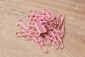Pink paper clips and binder on the table
