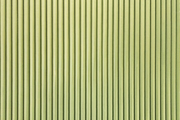 Green corrugated texture background with vertical lines.