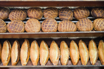 Freshly baked bread loaves stacked on wooden shelves