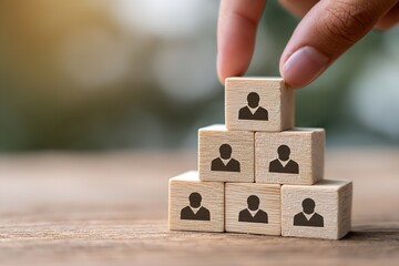 Building a strong team concept with wooden blocks showing people icons in a pyramid structure