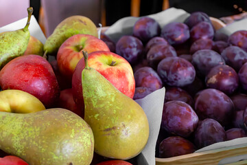 Autumn fruits – baskets with ripe pears, apples and plums at a local market or exhibition, natural seasonal produce from a Polish orchard