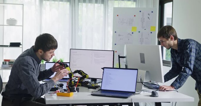 Team of male developers work code control robotics system and software automation project write prompt AI data bot at office. Artificial intelligence, collaboration, robotic, debugging, machine learn.