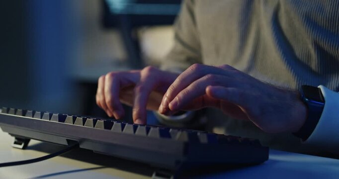 Closeup young adult male freelance developer typing write prompt AI bot app program nomad terminal coding at office night. Artificial intelligence dashboard, robotics user interface, machine learning.