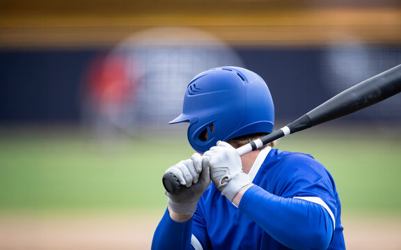Rear view of a baseball player standing at home plate ready to hit a ball. Good generic baseball action image of a batter ready to swing