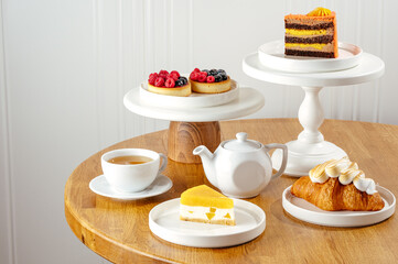 cheesecake, croissant, tartlet with berries and tea