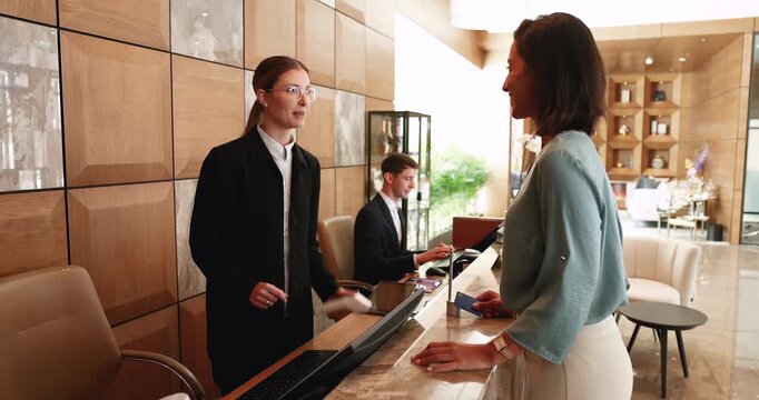 Guest paying and receiving room keycard at hotel reception