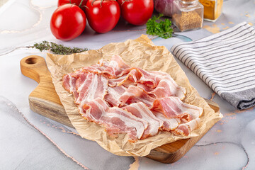 Sliced pork bacon over board
