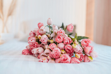 Pink tulips bouquet on white bedsheet. Gentle floral gift for romantic bedroom, copy space.