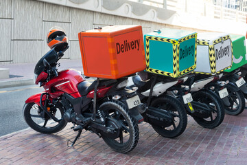 Scooters with delivery boxes parked on residential street.