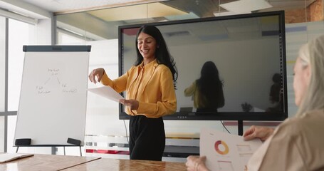 Woman distributing documents with charts and business data to colleagues - Powered by Adobe