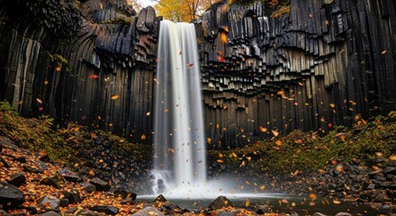 Tall basalt column waterfall with glowing sunlight