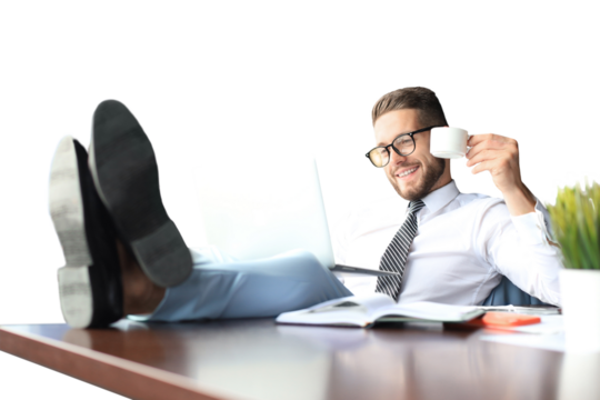 Handsome businessman sitting with legs on table and drinking coffee on a transparent background