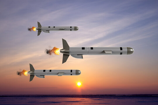 Three Tomahawk cruise missile flying towards the target against the sunset
