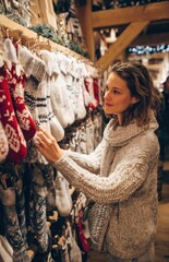 Obraz premium Woman shopping for handmade socks at christmas market