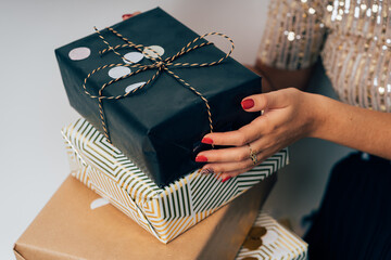 Woman holding stack of festive holiday gifts