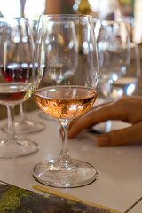 Close-up of a glass of rose wine on a tasting table with blurred background. Perfect for wine, food, lifestyle, and luxury concepts.