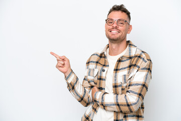 Naklejka premium Young caucasian handsome man isolated on white background pointing finger to the side