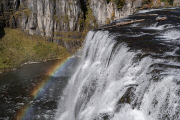 Fototapeta premium Rainbow. Upper Mesa Falls is a waterfall on the Henrys Fork in the Caribou-Targhee National Forest. Fremont County, Idaho. Henrys Fork (Snake River tributary). Basalt 