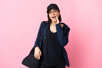 Young sport woman with sport bag isolated on pink background shouting with mouth wide open