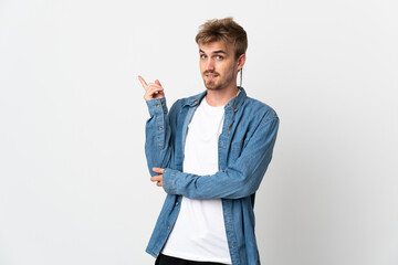 Young handsome man isolated on white background happy and pointing up