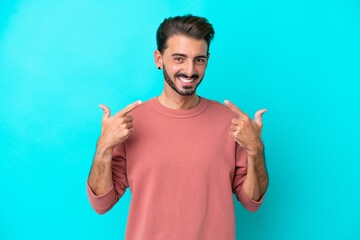 Fototapeta premium Young caucasian man isolated on blue background giving a thumbs up gesture