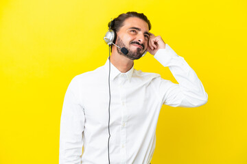 Telemarketer caucasian man working with a headset isolated on yellow background having doubts and...