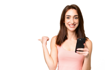 Young caucasian woman over isolated chroma key background using mobile phone and pointing to the lateral