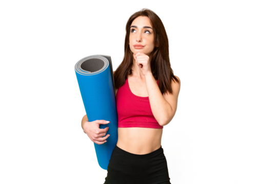 Young sport caucasian woman going to yoga classes while holding a mat over isolated chroma key background and looking up - Powered by Adobe