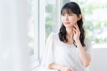 リビングでスキンケアをするミドルの女性